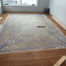 Carpet was removed from the center of the dining room. The space was then filled in on a 45 with a walnut / maple border and a walnut, oak and maple inlay. Oak was stained with Latte Macchiato with a satin finish on top.